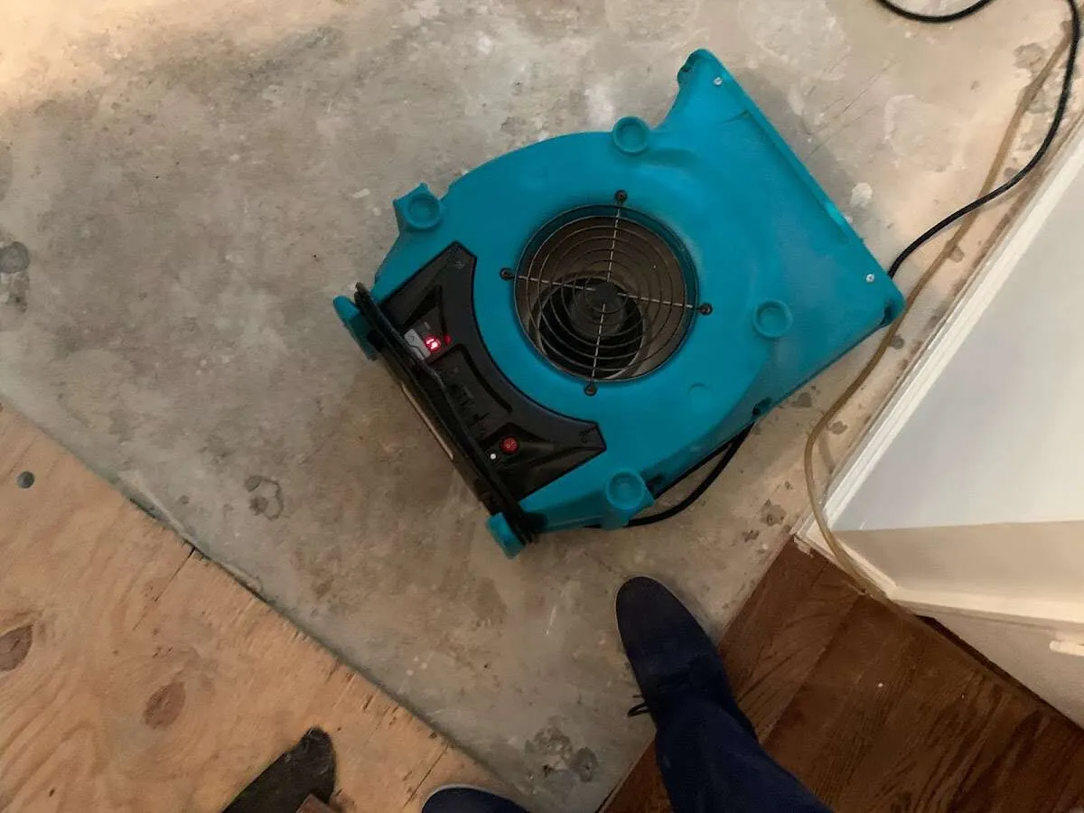 Air mover drying subfloor during Commercial Water Damage Restoration in Clayton